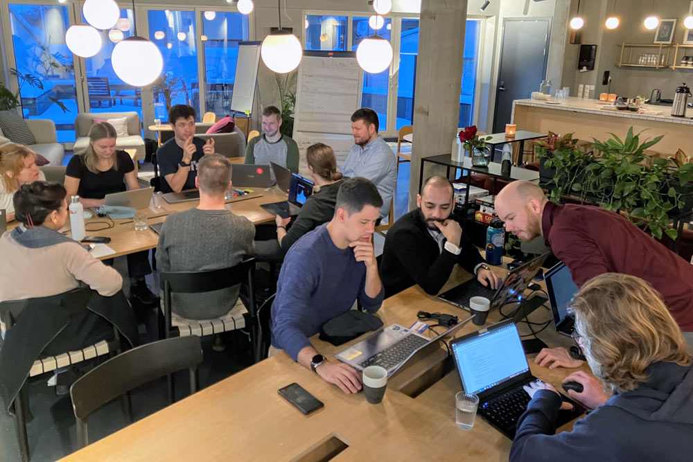 A group of people with laptops, collaborating in an co-working space.